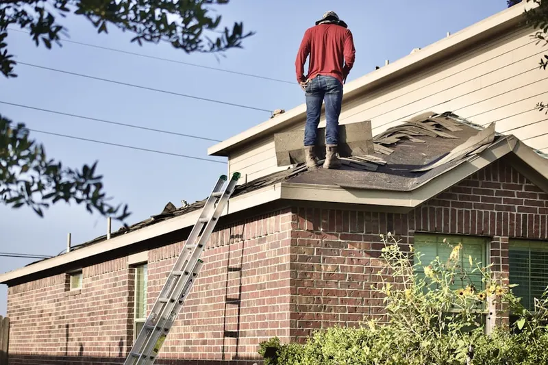 Professional roofer working on a residential roof in Bennett